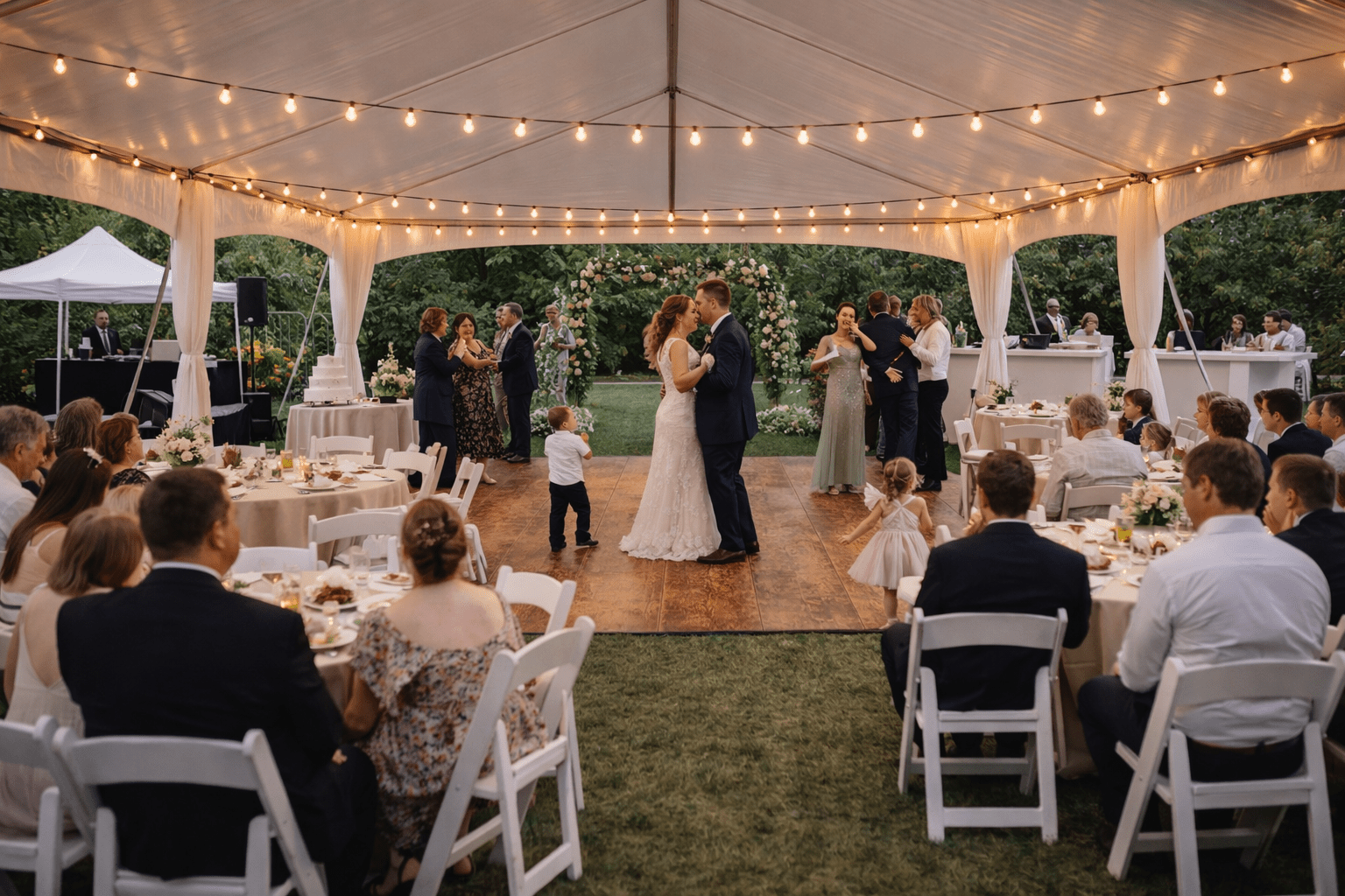 20x40 frame tent wedding reception with dining tables, dance floor, and guests celebrating under string lights