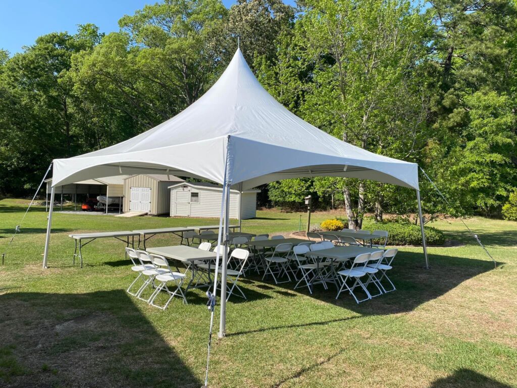 White frame tent setup in backyard for outdoor party rental