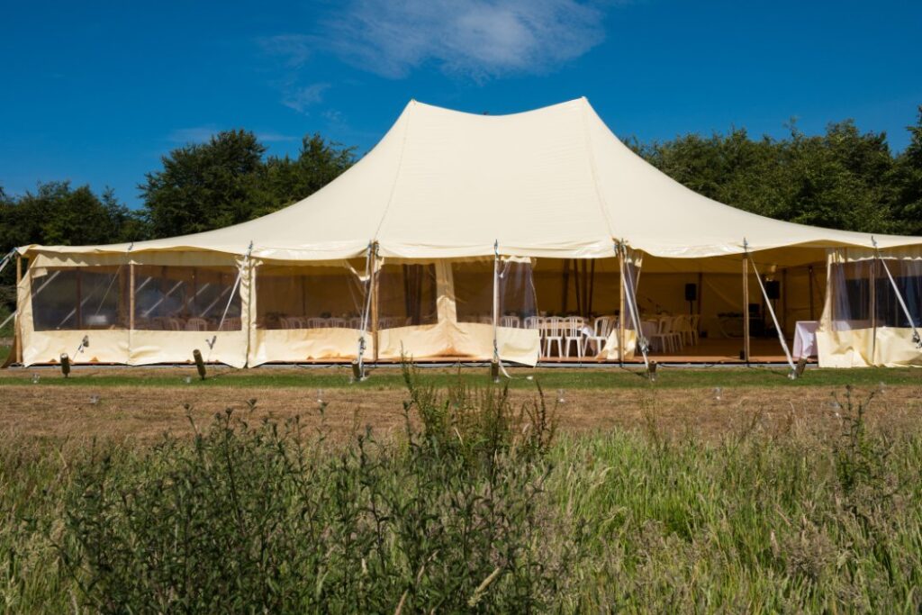 Large white pole tent setup for outdoor wedding or event rental