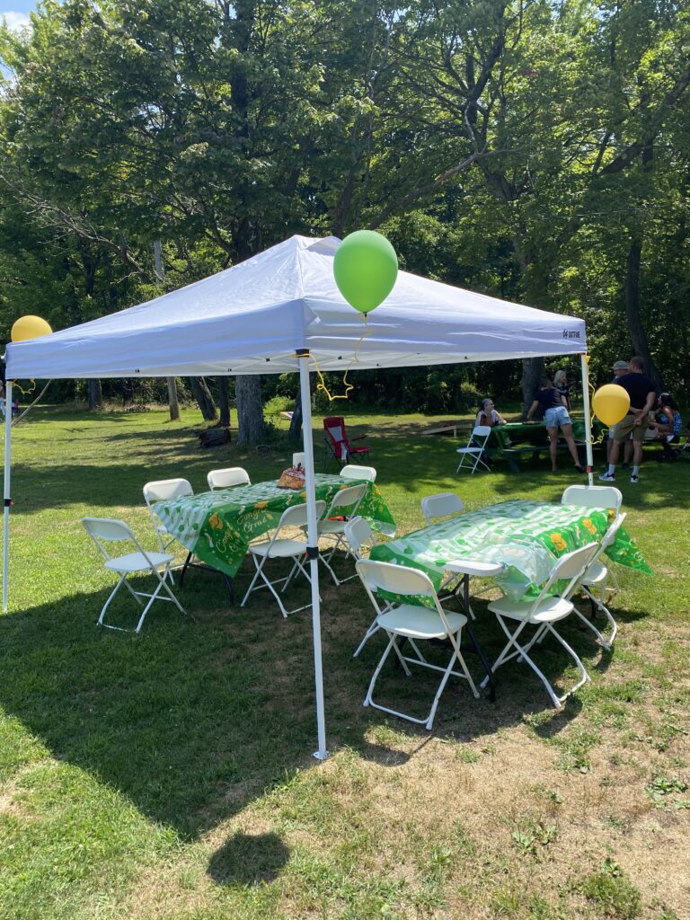 Small party tent with tables and chairs setup for outdoor celebrations.