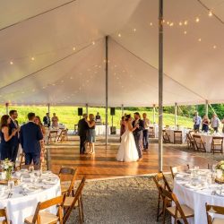 Wedding reception under tent with string lights and dance floor