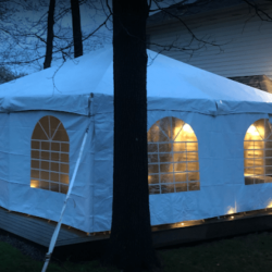 Enclosed event tent with sidewalls and lighting for outdoor evening event