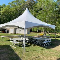 White frame tent setup in backyard for outdoor party rental