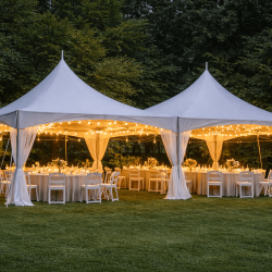 Two connected 20x20 high-peak tent rentals in Pittsburgh, PA with sidewalls and windows, warmly lit inside for an evening event.