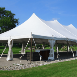 White event tent setup on grass for an outdoor wedding or special event